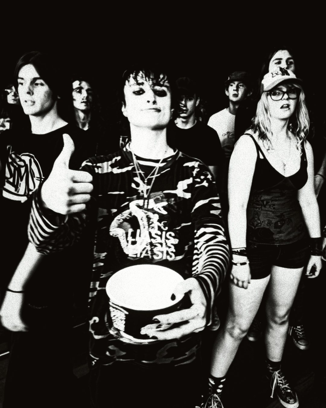The scene kids in the pit, black and white, one holding a floor tom